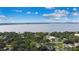 Scenic aerial view of a residential area with lush greenery and a large body of water in the distance at 328 E Minnehaha Ave, Clermont, FL 34711