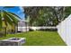 Spacious backyard featuring a fire pit, a white fence, and greenery, perfect for outdoor enjoyment and relaxation at 328 E Minnehaha Ave, Clermont, FL 34711