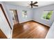 Well-lit bedroom showcasing hardwood floors, two windows, ceiling fan and light gray walls at 328 E Minnehaha Ave, Clermont, FL 34711