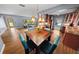 Open dining area featuring a stylish light fixture and views through a window, with hardwood floors at 328 E Minnehaha Ave, Clermont, FL 34711