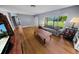 Spacious living room with hardwood floors, a comfortable sofa, and natural light from the large window at 328 E Minnehaha Ave, Clermont, FL 34711