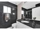 Modern bathroom featuring black marble walls, white vanity, and shower with glass doors at 3926 Ventura Place, Orlando, FL 32822