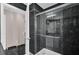 Modern bathroom featuring black marble walls and shower with glass doors at 3926 Ventura Place, Orlando, FL 32822