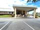An inviting clubhouse entrance is framed by well-maintained landscaping and a circular driveway at 3926 Ventura Place, Orlando, FL 32822