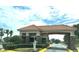 The attractive community entrance boasts mature landscaping, a guardhouse, and decorative hardscaping at 3926 Ventura Place, Orlando, FL 32822