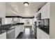 Modern kitchen featuring white cabinets, black countertops, and stainless steel appliances at 3926 Ventura Place, Orlando, FL 32822