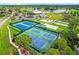 Aerial view of tennis courts with playground, clubhouse, pool, and golf course in the background at 3926 Ventura Place, Orlando, FL 32822