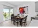 Dining area with a modern table set, sliding door access, and contemporary wall art at 4223 Little Owl Ln, Kissimmee, FL 34746