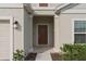 Inviting entryway featuring a solid front door, decorative sidelight, and manicured landscaping at 4223 Little Owl Ln, Kissimmee, FL 34746