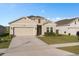 Charming single-story home with a well-maintained lawn, attached garage, and neutral color palette at 4223 Little Owl Ln, Kissimmee, FL 34746