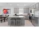 Open kitchen featuring stainless steel appliances, a central island, and a view into the dining area at 4223 Little Owl Ln, Kissimmee, FL 34746