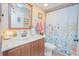 Charming bathroom with a wood vanity, marble countertop, and floral shower curtain at 4545 Southfield Ave, Orlando, FL 32812