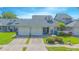 Charming exterior showcases a well-maintained townhome with a two-car garage and lush landscaping at 4545 Southfield Ave, Orlando, FL 32812