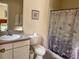 Bright bathroom with a floral shower curtain, neutral color scheme and a framed picture on the wall at 4778 Vero Beach Pl, Kissimmee, FL 34746