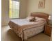 Cozy bedroom featuring a queen bed with patterned linens and a large window with natural light at 4778 Vero Beach Pl, Kissimmee, FL 34746