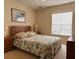 Inviting bedroom features a queen bed with floral bedding and a bright window creating a relaxing atmosphere at 4778 Vero Beach Pl, Kissimmee, FL 34746