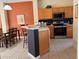 Well-equipped kitchen with sleek appliances and wooden cabinetry, open to the dining area, for convenience and style at 4778 Vero Beach Pl, Kissimmee, FL 34746