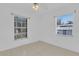Bright, empty bedroom with tiled floors, white walls, and two large windows at 517 Ivanhoe Way, Casselberry, FL 32707
