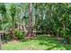 Scenic view of the backyard featuring lush landscaping and a pond surrounded by mature trees at 5301 Burning Tree Dr # F, Orlando, FL 32811