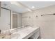 Bright bathroom featuring a double sink vanity, a large mirror, and a walk in shower at 5301 Burning Tree Dr # F, Orlando, FL 32811