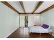 Light-filled bedroom featuring wood floors, exposed beam ceiling, and sliding glass door to outdoor space at 5301 Burning Tree Dr # F, Orlando, FL 32811