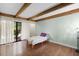 Light-filled bedroom featuring wood floors, exposed beam ceiling, and sliding glass door to outdoor space at 5301 Burning Tree Dr # F, Orlando, FL 32811