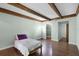 Bright bedroom featuring wood floors, a bed, and wood beam ceiling at 5301 Burning Tree Dr # F, Orlando, FL 32811