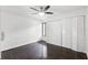 Bedroom featuring dark hardwood floors, multiple closets, a ceiling fan and a window at 5301 Burning Tree Dr # F, Orlando, FL 32811