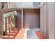 An up-close entrance to the building with light brown wooden siding and mulched garden beds at 5301 Burning Tree Dr # F, Orlando, FL 32811