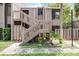 Two-story condo with light brown wooden siding and exterior stairways to the upper unit entrances at 5301 Burning Tree Dr # F, Orlando, FL 32811