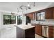Bright kitchen features wood cabinets, stainless steel appliances, island, and an attached sunroom at 5301 Burning Tree Dr # F, Orlando, FL 32811