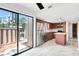 Bright kitchen features wood cabinets, stainless steel appliances, island, and sliding doors to patio at 5301 Burning Tree Dr # F, Orlando, FL 32811