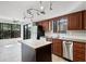 Bright kitchen features wood cabinets, stainless steel appliances, island, and stylish track lighting at 5301 Burning Tree Dr # F, Orlando, FL 32811