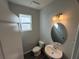 Well-lit bathroom featuring a single sink vanity, modern fixtures, and tile flooring at 551 Pothos St, Apopka, FL 32703