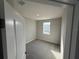 New construction bedroom with plush gray carpeting and a window providing views of the outdoors at 551 Pothos St, Apopka, FL 32703