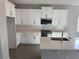 Modern kitchen featuring quartz countertops, white cabinets and island, and stainless appliances at 551 Pothos St, Apopka, FL 32703