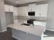 Modern kitchen with island, quartz countertops, stainless appliances, and white cabinetry at 551 Pothos St, Apopka, FL 32703