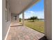 Covered back porch with brick pavers overlooking a grassy yard and pond at 5550 Sabal Dr, St Cloud, FL 34771