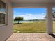 A covered back porch with brick pavers overlooking a pond and grassy yard at 5550 Sabal Dr, St Cloud, FL 34771