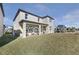 Backyard view of a two-story home showcasing a covered patio and green lawn at 5550 Sabal Dr, St Cloud, FL 34771