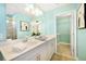 Bright bathroom featuring a double vanity, decorative mirror, and walk-in closet at 5550 Sabal Dr, St Cloud, FL 34771