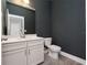 A half-bath with dark gray walls, white vanity, and luxury vinyl plank flooring at 5550 Sabal Dr, St Cloud, FL 34771