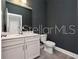 Bathroom features a white sink vanity, toilet, and a dark gray wall at 5550 Sabal Dr, St Cloud, FL 34771