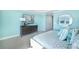 Stylish bedroom with soft blue walls, a dresser, and a picturesque view of the lake at 5550 Sabal Dr, St Cloud, FL 34771