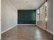 Bright bedroom features a dark green accent wall, light gray walls, and natural light from the double windows at 5550 Sabal Dr, St Cloud, FL 34771