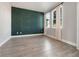 Elegant bedroom features a dark green accent wall, light gray walls, and natural light from the double windows at 5550 Sabal Dr, St Cloud, FL 34771