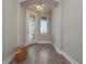 Bright foyer features gray walls, wood floor, decorated glass door and decorative light fixture at 5550 Sabal Dr, St Cloud, FL 34771