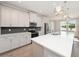 Open kitchen featuring white cabinets, quartz countertops, stainless appliances and backsplash at 5550 Sabal Dr, St Cloud, FL 34771