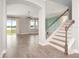 Bright living room with wood floors, staircase, gray walls, and view of yard with lake at 5550 Sabal Dr, St Cloud, FL 34771