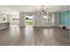 Spacious living room boasts wood floors, modern lighting, large windows, and views of the lake at 5550 Sabal Dr, St Cloud, FL 34771
